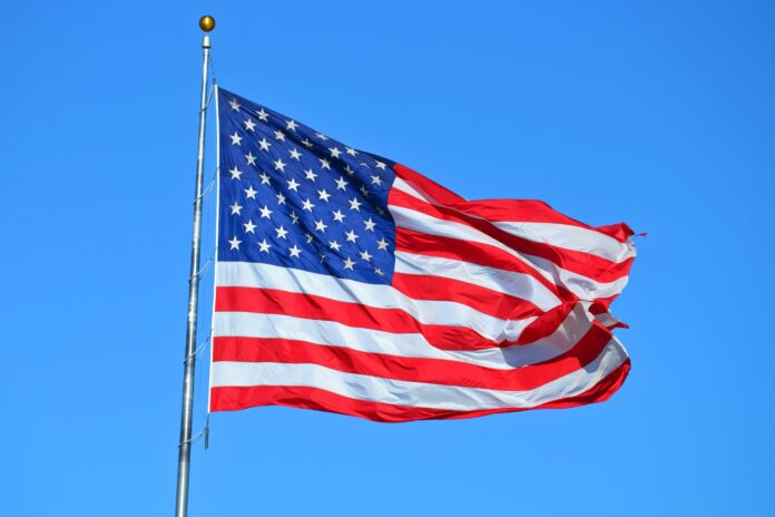 American flag flies against blue sky