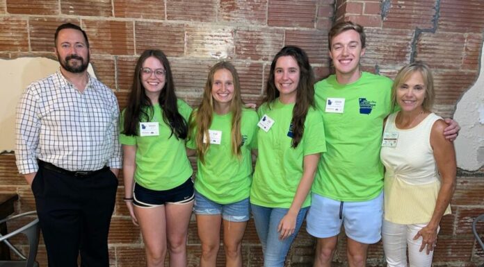Georgia Rural Health Innovation Center assesses housing, health in Chattooga County four students wearing bright green shirts are flanked by a man and woman