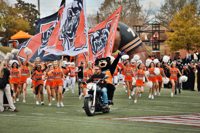 Mercer football team entrance with Bear mascot and motorcycle