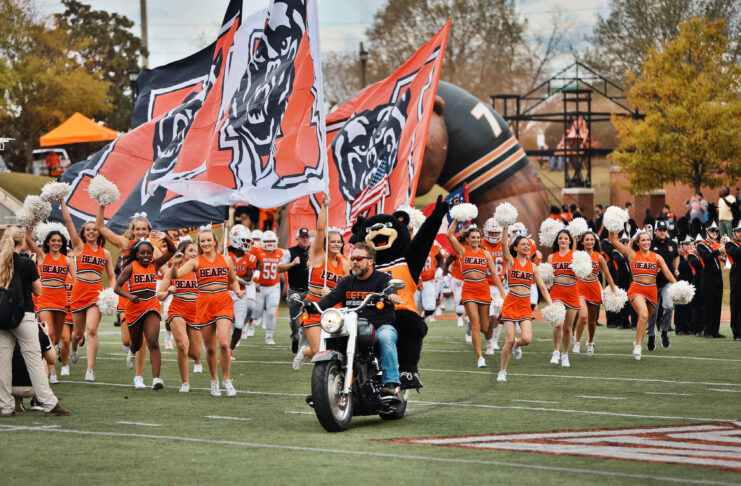 Mercer football team entrance with Bear mascot and motorcycle