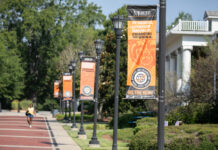 Office of Global Engagement awards 27 scholarships for students to study abroad Exterior campus street posts with orangge banners stating "At Mercer Everyone Majors In Changing the World"