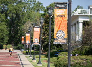 Office of Global Engagement awards 27 scholarships for students to study abroad Exterior campus street posts with orangge banners stating "At Mercer Everyone Majors In Changing the World"