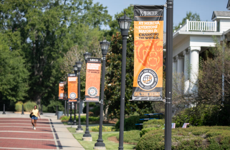 Exterior campus street posts with orangge banners stating 