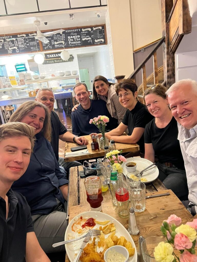 Eight people can be seen sitting around a table at a restaurant.