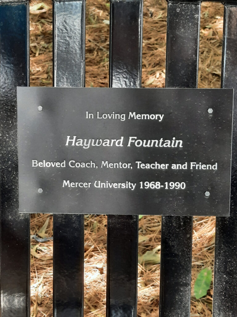plaque on bench reads: in loving memory, hayward fountain, beloved coach, mentor, teacher and friend, mercer university 1968-1990
