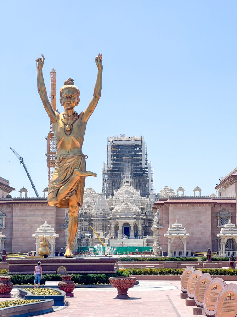 golden statue in front of temple under construction