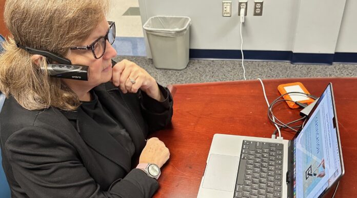 Mercer’s new user experience mobile lab allows for usability testing on the go A woman sits at a desk and looks at a laptop.