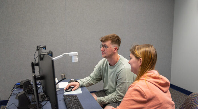 Rebrand puts Mercer program at forefront of technological change Two students sit at a desk and look at two computer screens.