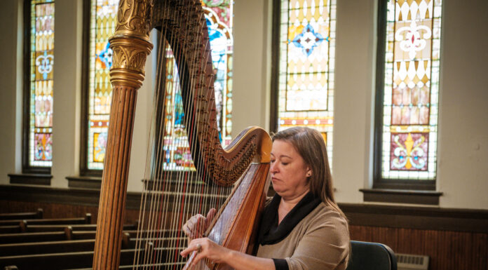 Mercer professor restores 105-year-old harp for students’ future use seated woman plays harp