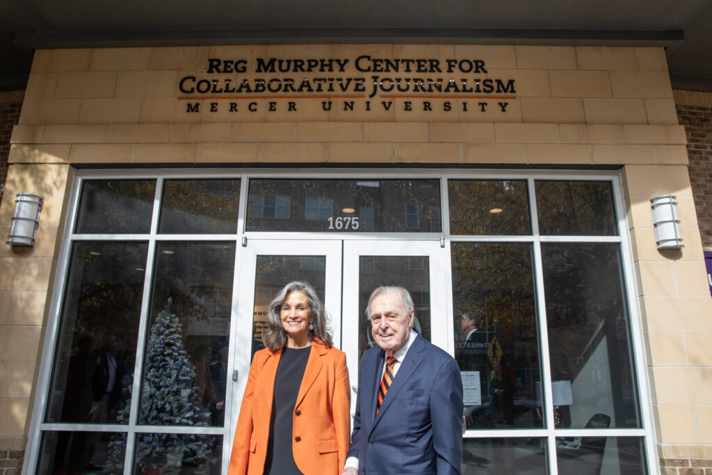 man and woman stand in front of a building that bears the name Reg Murphy Center for Collaborative Journalism