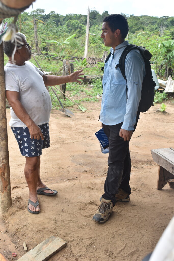A local resident of Guyana speaks with a male student outside.