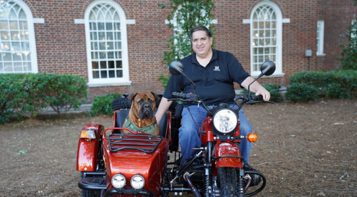 Therapy dog provides stress relief, joy to Mercer Law students and beyond A man sits atop a motorcycle with a dog in the attached side car
