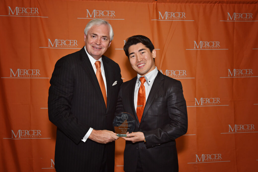 Mercer University's president presents an alumnus with an award.