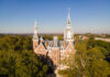 5 Mercer students selected for inaugural Presidential Fellowship A drone photo of a five-story brick building with tall spires, with trees surrounding it.