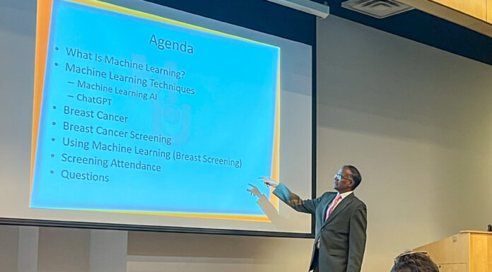 Informatics professor selected for Governor’s Teaching Fellowship Program A man points to an agenda displayed on a projection screen.