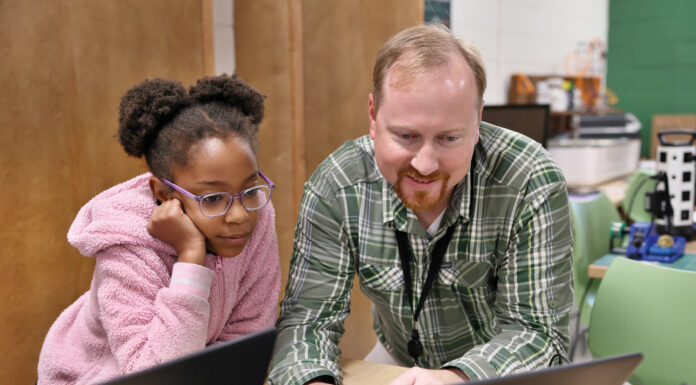 Mercer advances computer science education in rural Georgia a man shows a young girl something on a computer