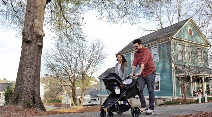 Mercer spurs neighborhood revitalization in historic part of Macon a man and woman push a baby stroller down a sidewalk with a home in the background