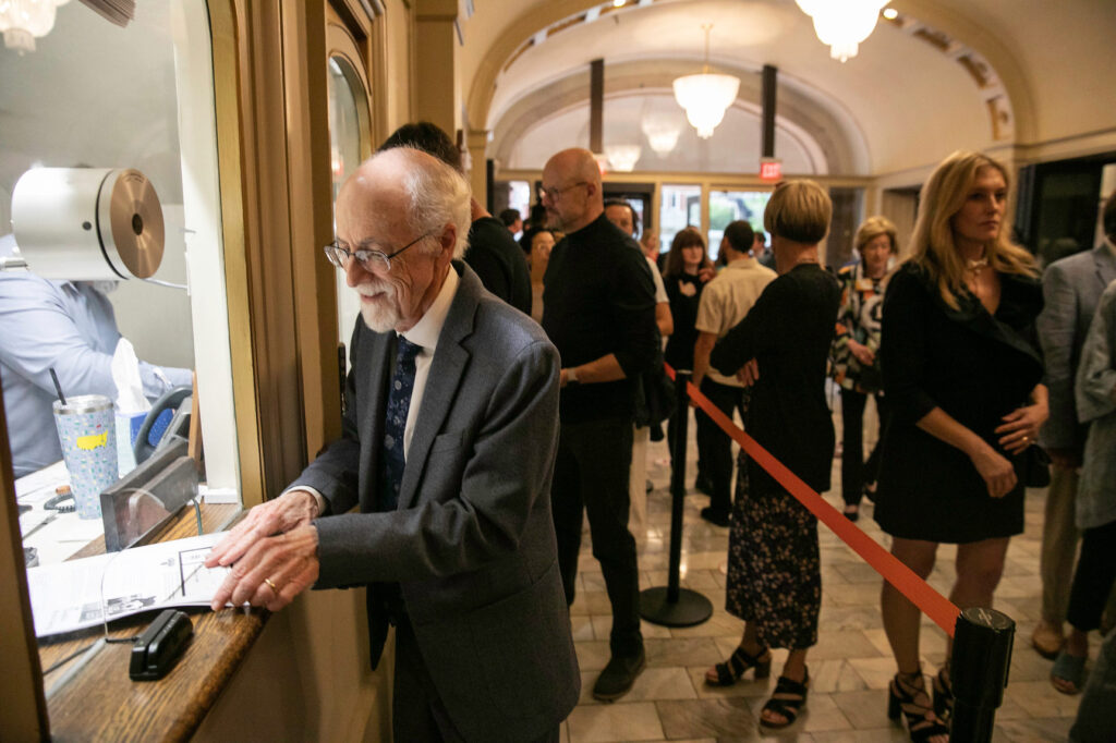 a man buys a ticket at the box office