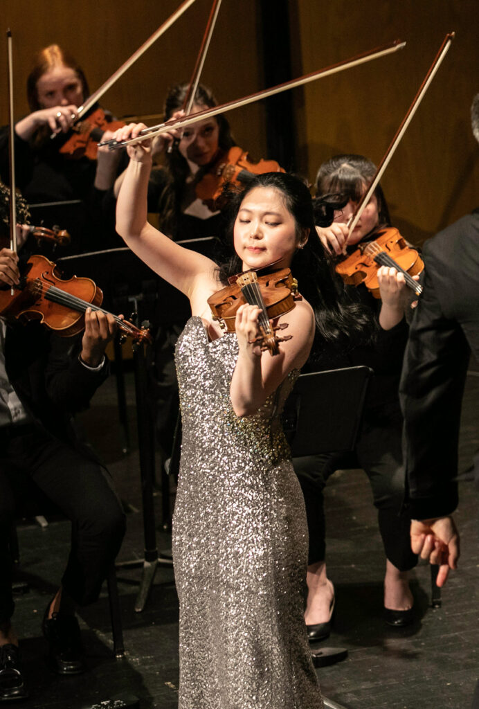 a woman plays violin on stage