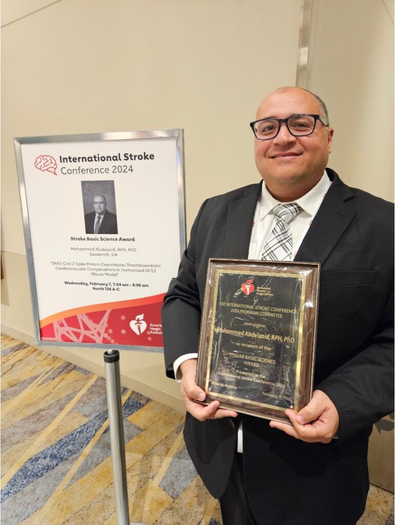 Dr. Abdelsaid standing holding ASA Award