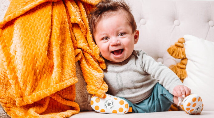 Parents start Brexton Foundation to honor 1-year-old son they lost a baby sits in a chair and leans against an orange blanket