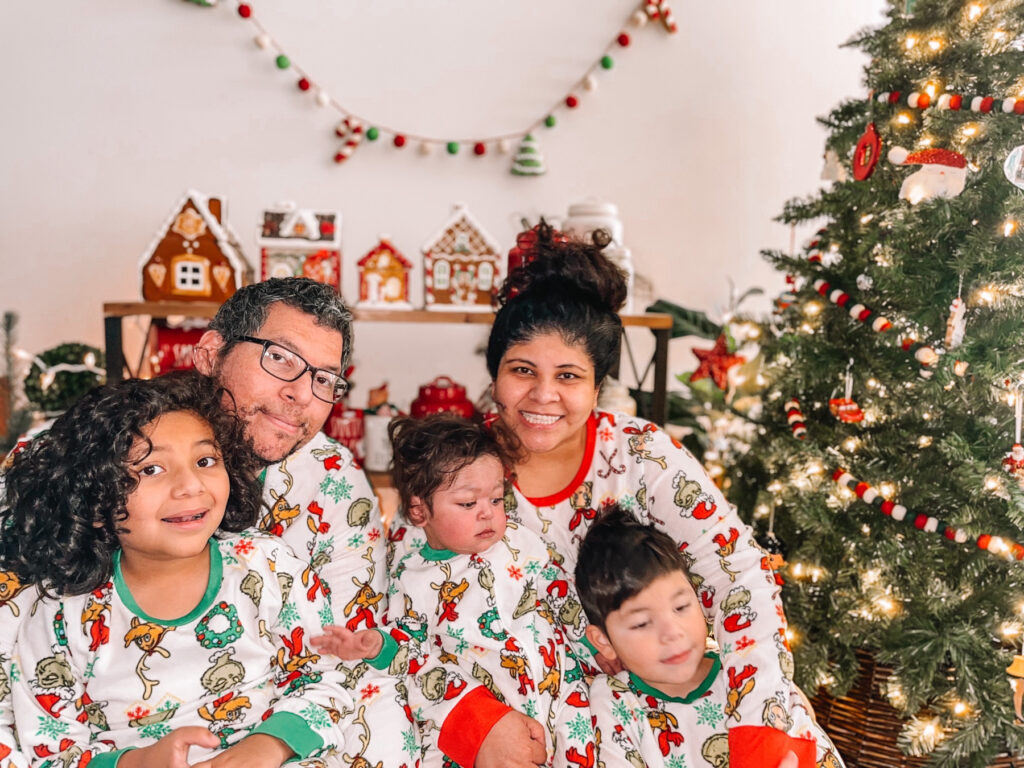 a mom and dad and three kids wearing christmas pjs