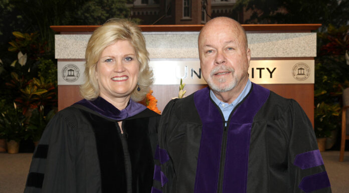 Mercer Law admission leads to love at first sight a man and woman stand next to each other in commencement attire
