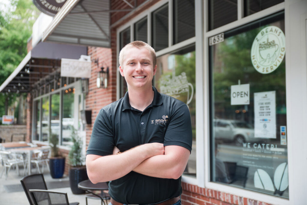 shane buerster stands with his arms crossed outside Z Beans Coffer in Mercer Village