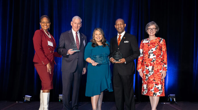 Mercer School of Law announces alumni award recipients A group of five adults stand on a stage