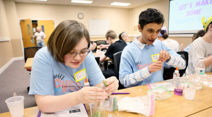 Mercer students show middle schoolers how fun engineering can be as a career a girl and boy mix materials in a cup