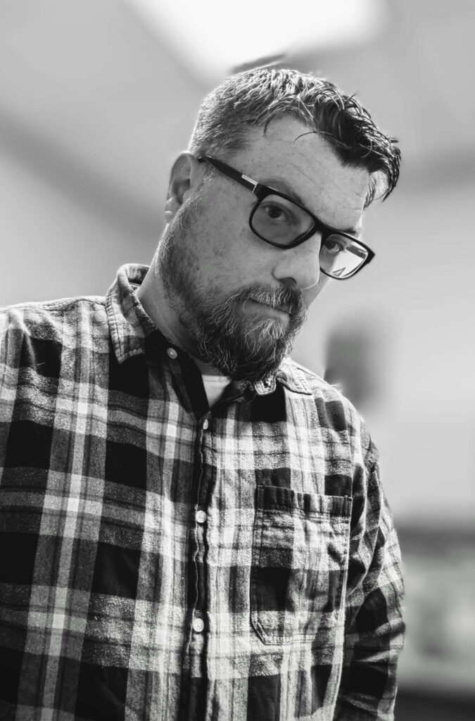 a black and white photo of a man wearing a plaid shirt