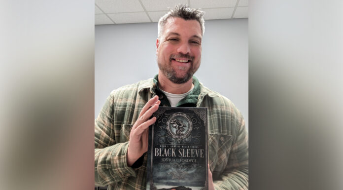Mom’s death inspires MERC employee to publish debut novel a man holds a book