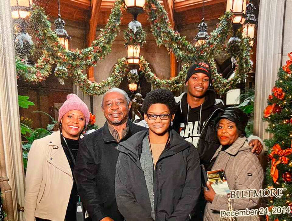 a family photo in front of christmas decorations
