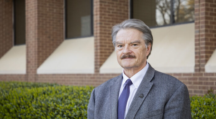 Medical school professor to receive Joe and Jean Hendricks Excellence in Teaching Award man in a suit stands in front of a building