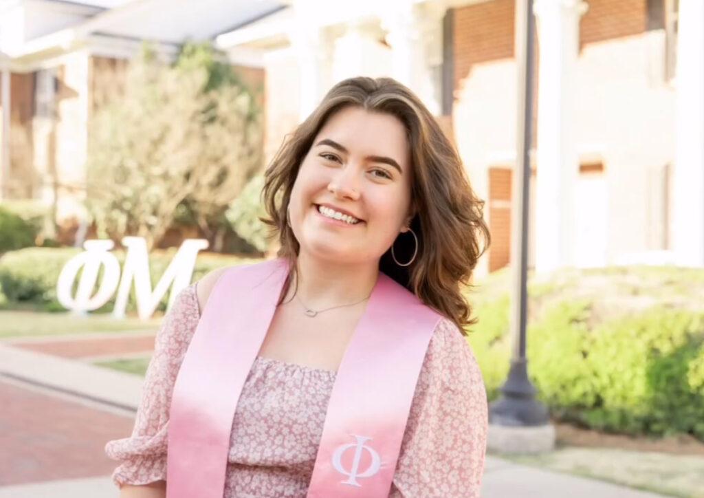 woman with a pink phi mu stoll around her neck