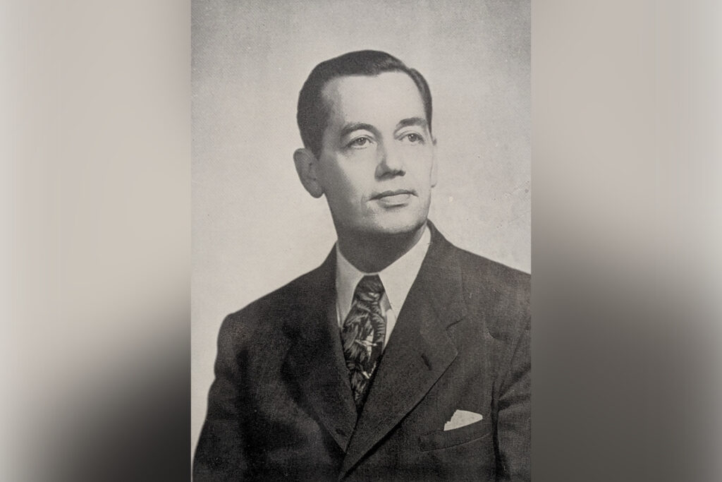 black and white head shot of a man wearing a suit and tie