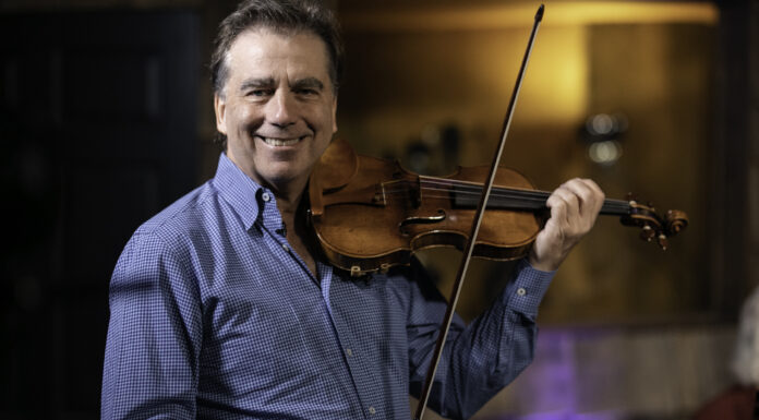 Mercer Center for Strings founder Robert McDuffie receives honorary degree from Emory Robert McDuffie holds up a violin and bow, smiling.