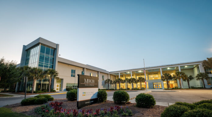 School of Medicine project provides support, community, resources for autism care Exterior view of the modern Mercer University School of Medicine building in Savannah at dawn, featuring landscaped gardens and a prominent university sign.