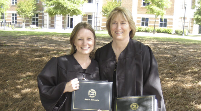 Mom and daughter will both receive master’s degrees from Mercer on Mother’s Day mom and daughter smile at the camera while wearing black graduation robes and holding their diplomas