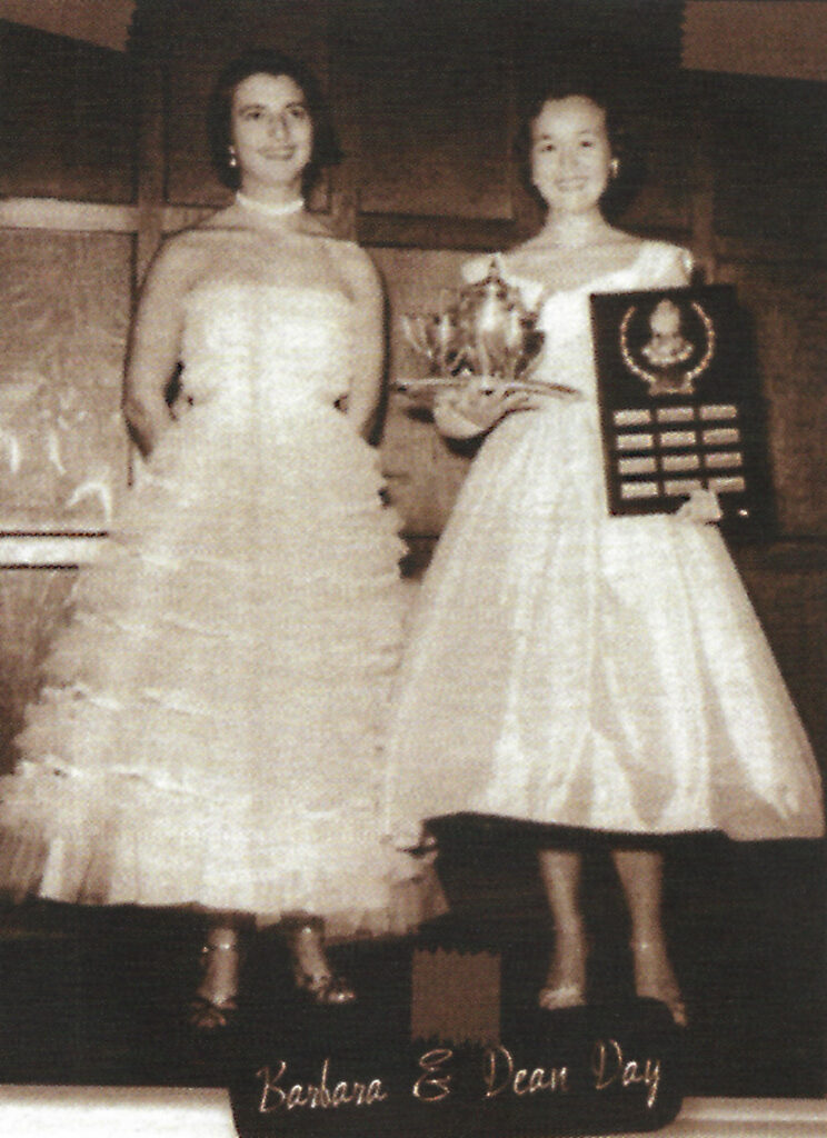 Two young women in formal 1950s-style dresses holding trophies, standing side-by-side. Text on image reads "Barbara & Dean Day."