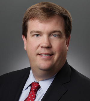 Headshot of Ivy Cadle wearing a black suit and red tie.