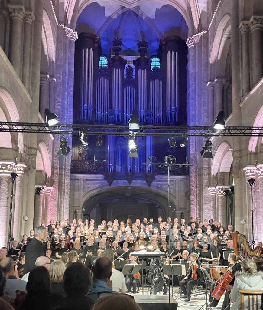 A choir in a cathedral sings in front of an audience.