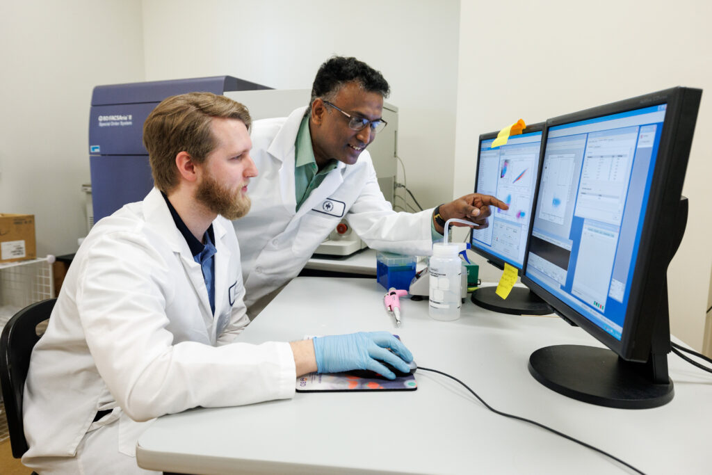 Dr. Raghavan Chinnadurai and a biomedical sciences student working in a lab.