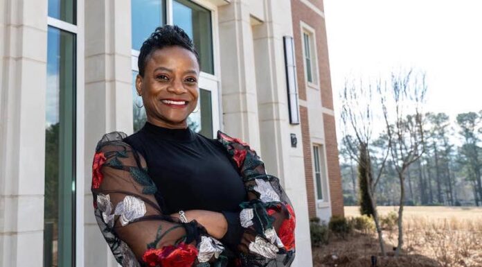 Interim dean achieved dream of being a pharmacist. Now she helps students do the same Dr. Pamela Moye stands in front of the College of Pharmacy. She is wearing a black top, her arms are crossed, and she is smiling.