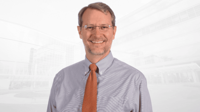 Headshot of D. Micah Hester wearing a collared shirt and tie.