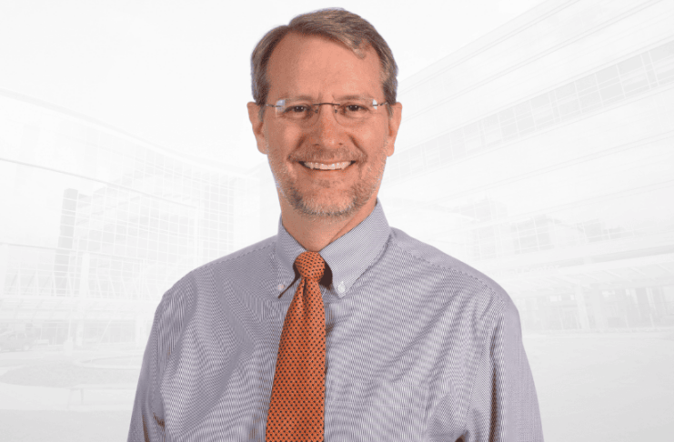 Headshot of D. Micah Hester wearing a collared shirt and tie.