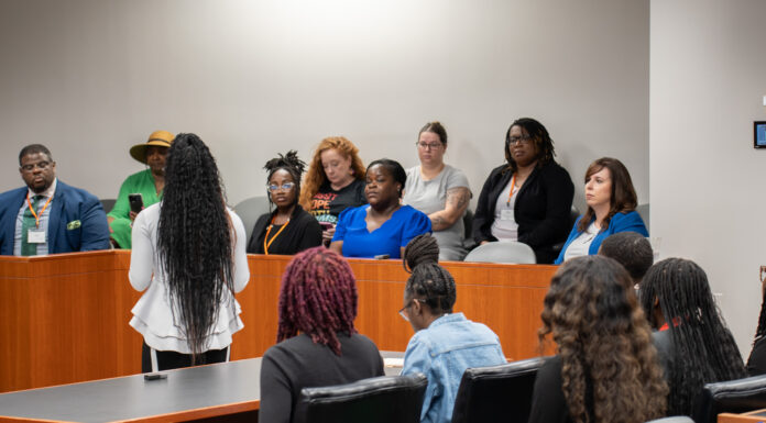 High school students get taste of law school at Mercer summer camp A diverse group of people sit in a jury box in a courtroom setting listening to a speaker who is standing.