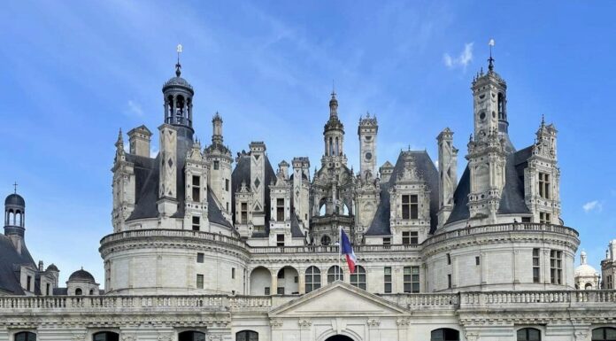 Journey to France: 80 years later, a new generation reflects on Normandy A group of students poses in front of a castle on a sunny day.