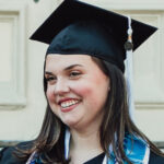 Headshot of Molly McRae wearing a black graduation cap and gown. She has a blue stole and cords around her neck.