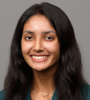 Headshot of Naya Patel wearing a dark green blouse and gold necklace.